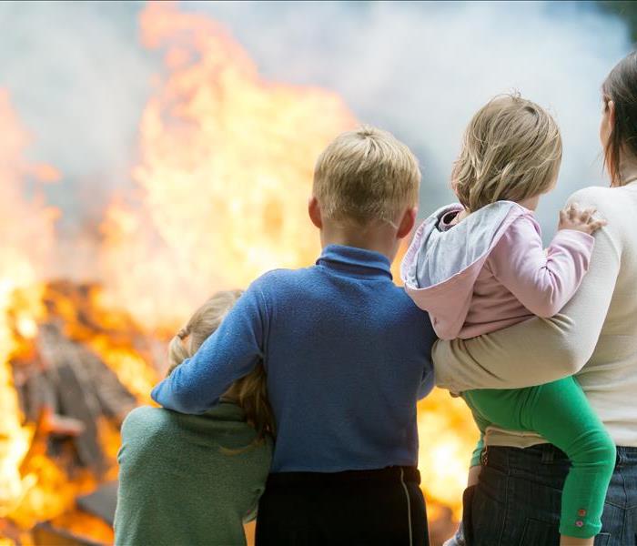 Family mother with children at burning house background